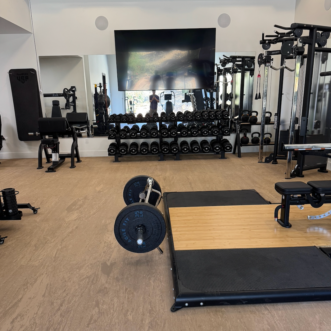 Gym interior with various equipment including weights and a treadmill.